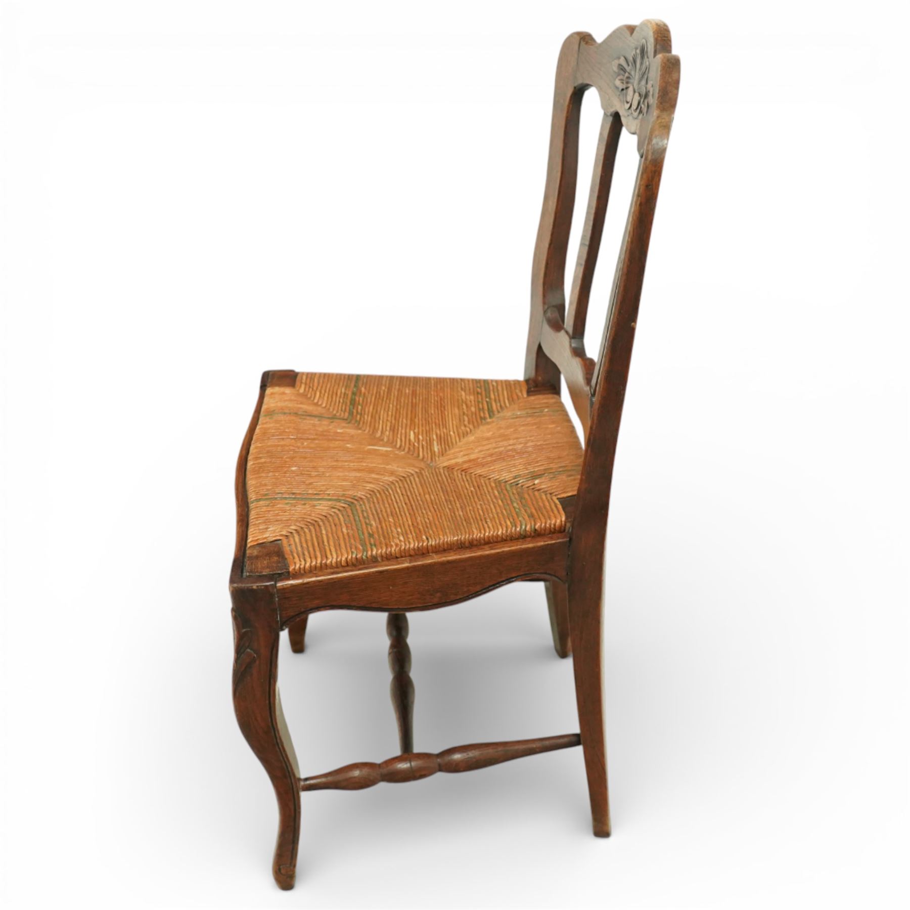 20th century French oak drawer-leaf extending dining table and six chairs, the rectangular parquetry top with moulded edge and rounded corners, pull-out draw leaves extending the table to 240cm, carved frieze with foliate detail, raised on cabriole supports with scroll terminals, the six matching chairs with shaped backs carved with floral motifs, paper cord seats woven with a green pattern, cabriole front supports and turned stretchers