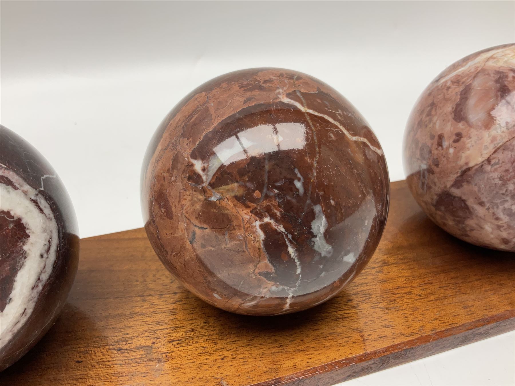 Set of three marble spheres on a elongated octagonal wooden base, H12cm