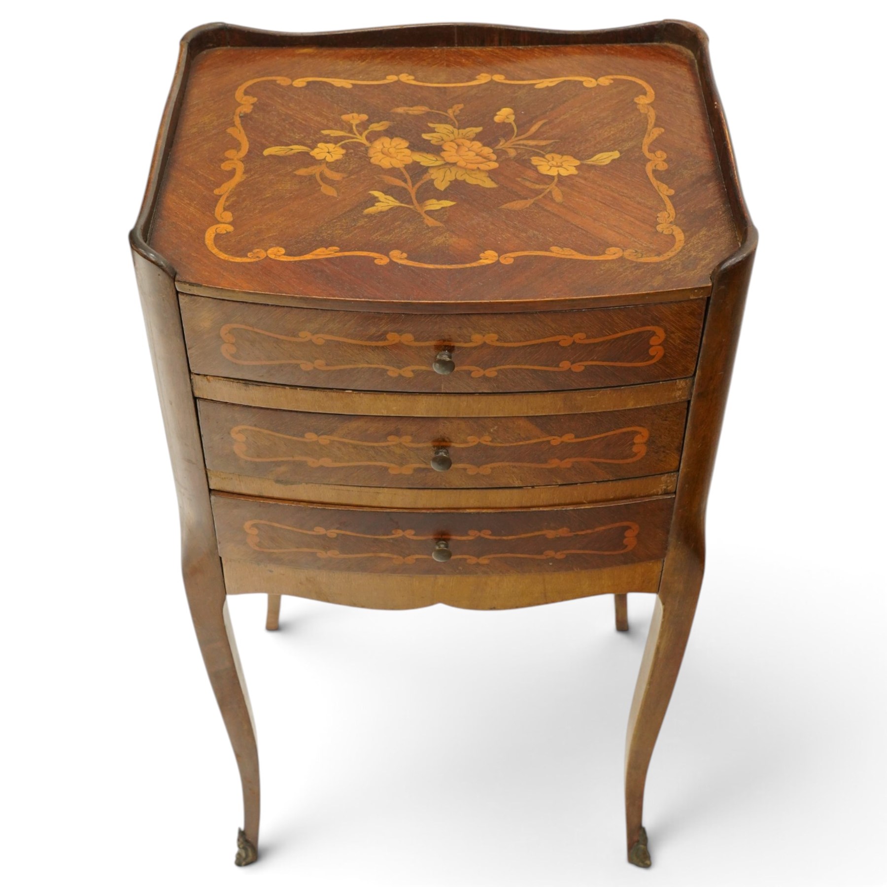 Matched pair of French inlaid floral marquetry bedsides, the three-quarter gallery tray top with central floral bouquet inlay and C-scroll border, one fitted with single frieze drawer over recessed cupboard and shaped apron, the other with three drawers, raised on tapering cabriole supports, with brass cartouche feet
