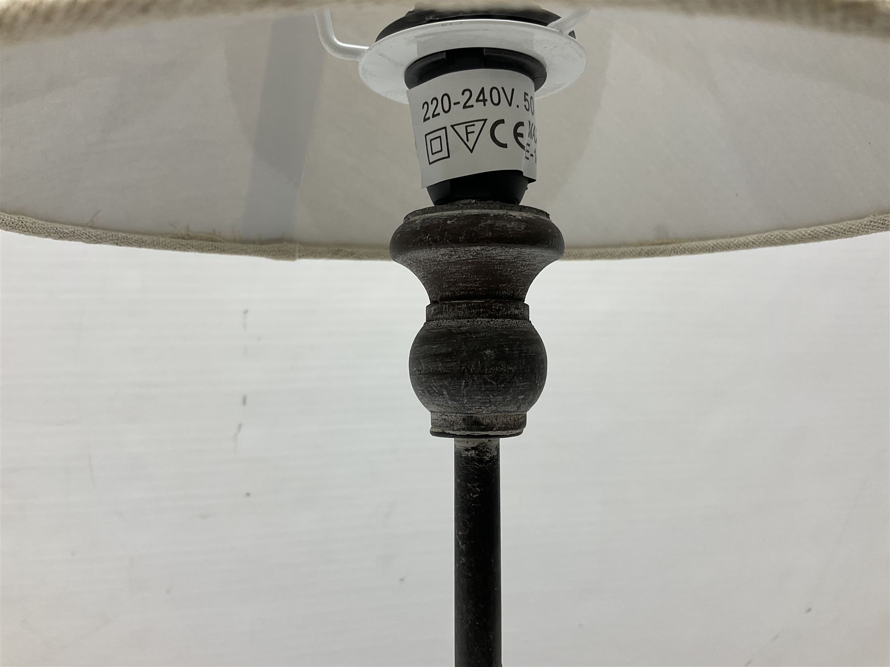 Table lamp, with a thin central stem upon a square stepped base, natural linen shade