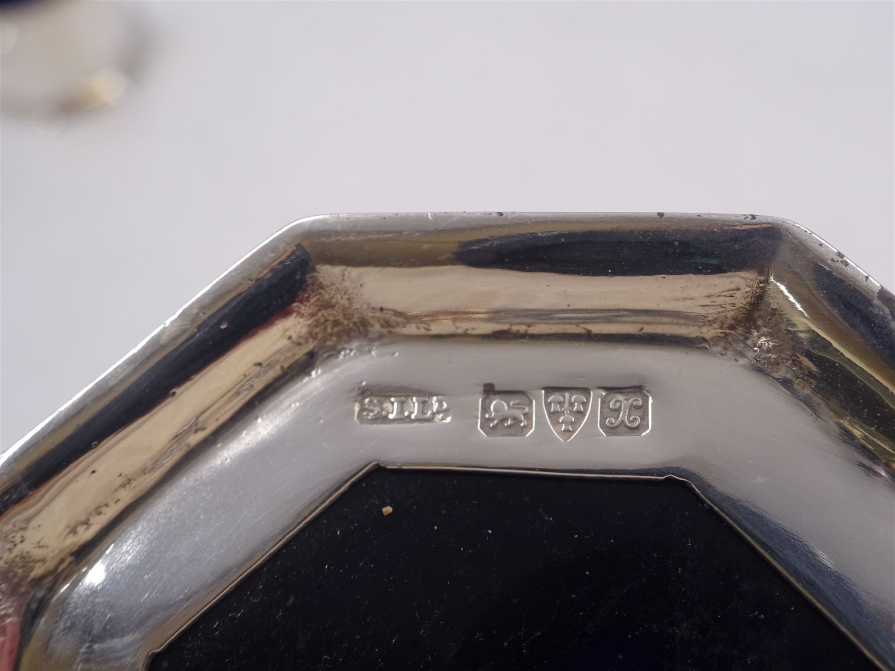 1920s silver three piece cruet set, comprising mustard pot and cover, pepper and open salt, each of faceted octagonal form, the mustard pot with pierced thumbpiece and capped handle, hallmarked Stokes & Ireland Ltd, Chester 1923 & 1924, max height 8.5cm, mustard and salt with original blue glass liners