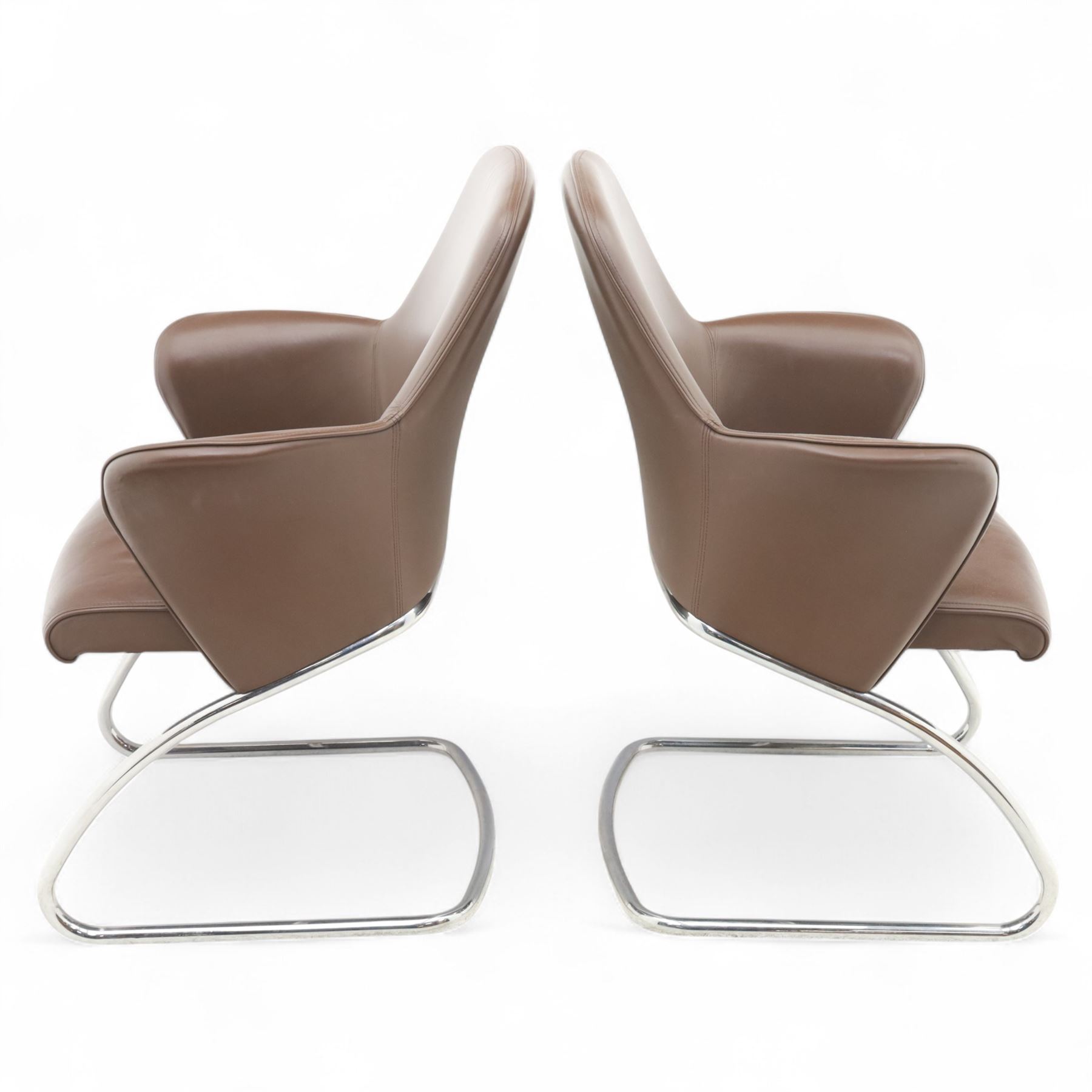 Four Senator executive cantilever chairs, upholstered in Padova hide, moulded back and integrated armrests, raised on a tubular chromed cantilever base