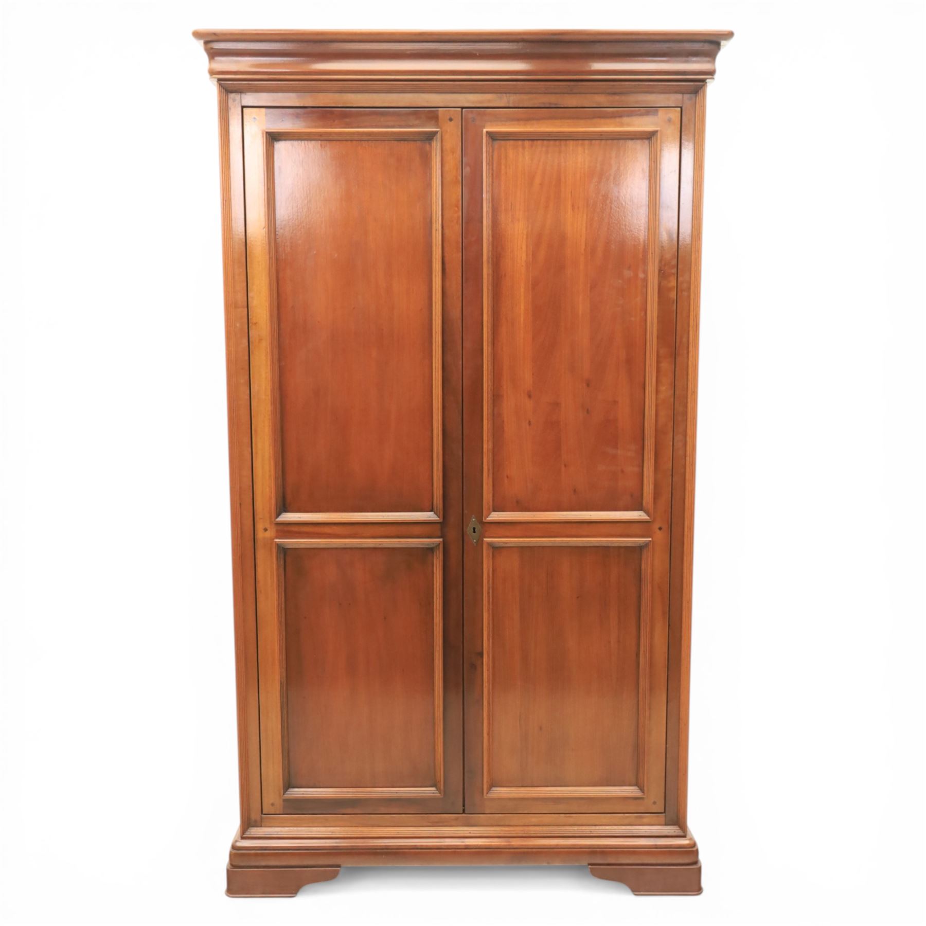 Willis & Gambier - French cherry double wardrobe, moulded cornice above panelled doors, enclosing a shelf and wooden hanging rail, raised on a moulded plinth with bracket feet