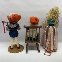 Anna Meszaros Hungary - three hand made needlework figurines - 'The Cobbler' as a child seated in a wooden rocking chair working on a removed boot H28cm; young girl in a long floral dress standing playing a harp H35cm; and young girl wearing a blue tabard standing playing a lute (3) Auctioneer's Note: Anna Meszaros came to England from her native Hungary in 1959 to marry an English businessman she met while demonstrating her art at the 1958 Brussels Exhibition. Shortly before she left for England she was awarded the title of Folk Artist Master by the Hungarian Government. Anna was a gifted painter of mainly portraits and sculptress before starting to make her figurines which are completely hand made and unique, each with a character and expression of its own. The hands, feet and face are sculptured by layering the material and pulling the features into place with needle and thread. She died in Hull in 1998.  