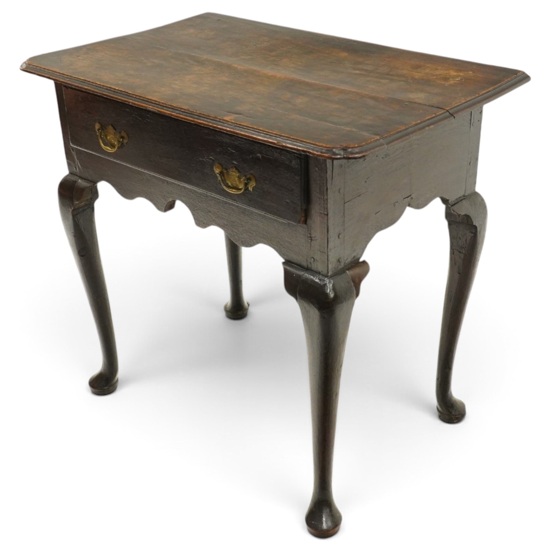 18th century oak lowboy, the rectangular top with moulded edge and eared front-corners, fitted with single drawer with pressed brass handle-plates, shaped apron over cabriole supports and pad feet