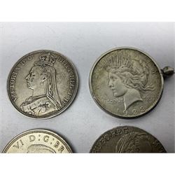 Four silver World coins comprising Queen Victoria 1889 crown, King George VI 1937 crown, Marie Thaler 1780 restrike, and mounted United States of America 1928 peace dollar 