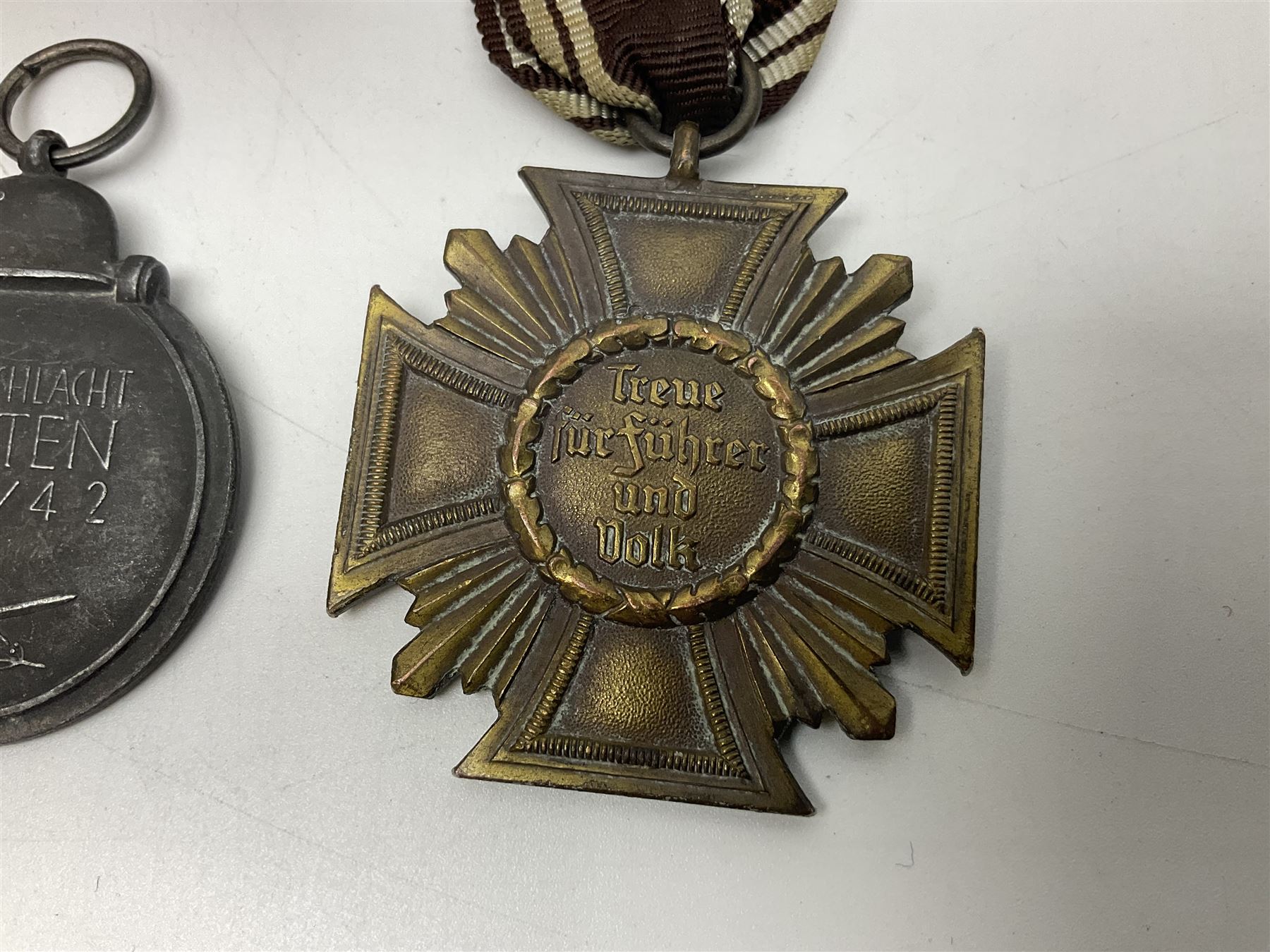 WW2 German Eastern Front Medal awarded to those who served on the German Eastern/Russian Front during the Winter Campaign period of 15th November 1941 to 15th April 1942 with original ribbon; German War Merit Cross with swords; and NSDAP Long Service Award (3)