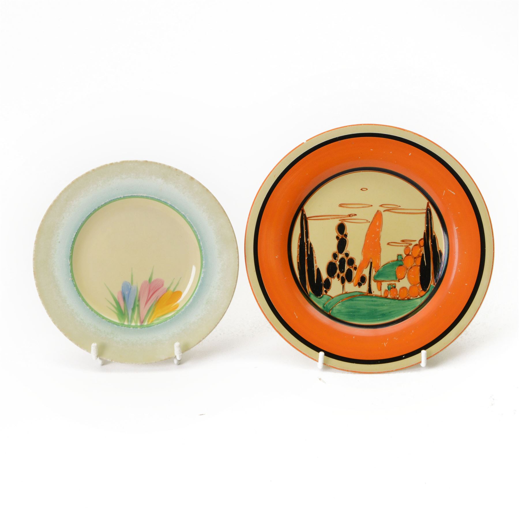 Clarice Cliff Orange Trees & House pattern side plate circa 1931, hand painted with a stylised tree and cottage landscape with orange and black banding, with printed mark beneath, together with a Clarice Cliff Spring Crocus pattern side plate, with printed mark beneath, largest D20cm  