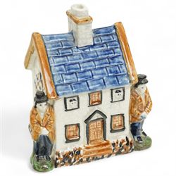 Yorkshire Prattware cottage, circa. 1820, in shades of blue, ochre and white, moulded in relief with two flanking gentlemen figures, H12cm 