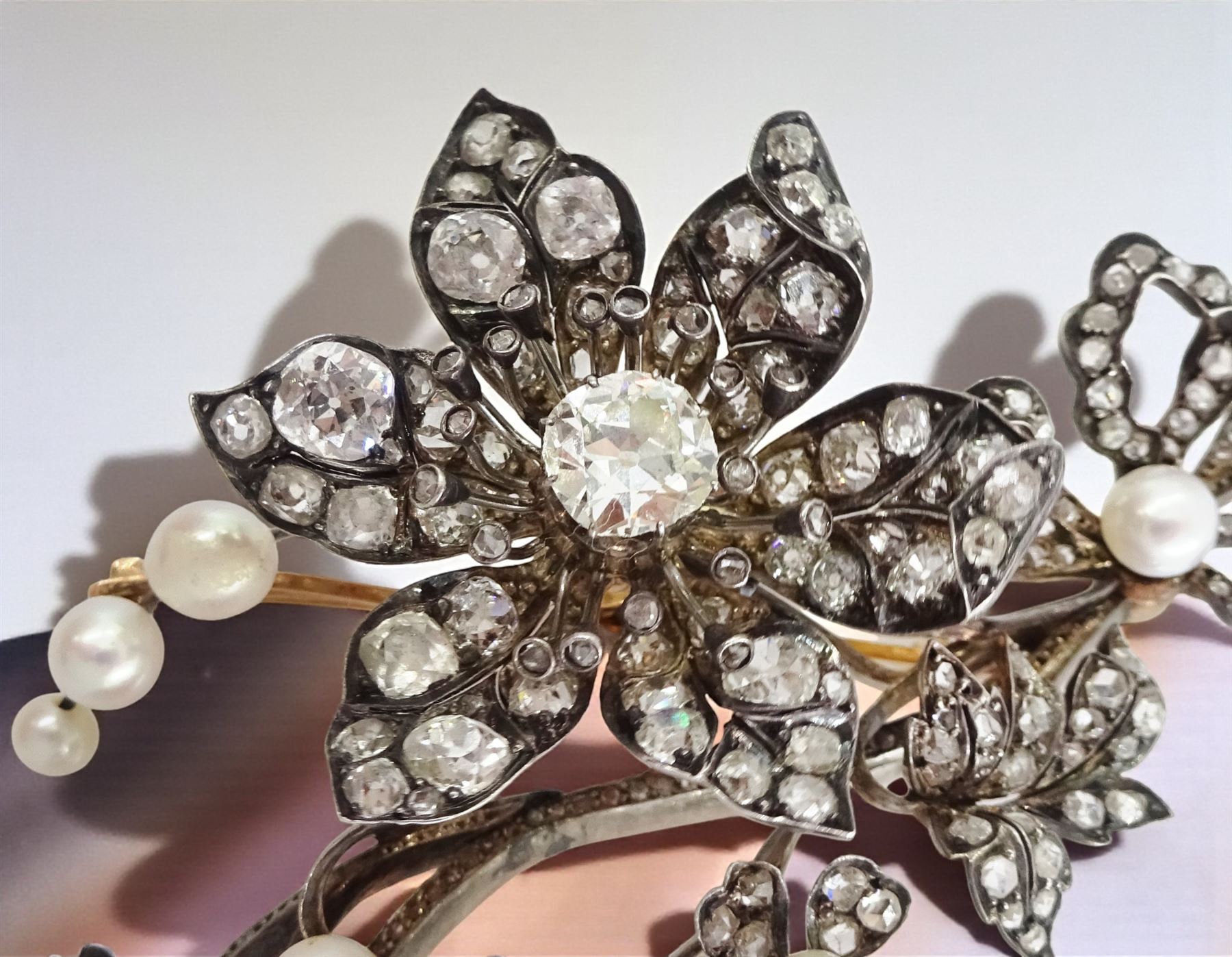 19th century gold and silver diamond and pearl en tremblant detachable brooch, the flower tremblant with a principal old cut diamond of approx 1.90 carat, the petals and stamen set with old cut and rose cut diamonds, total diamond weight approx 9.10 carat, to a foliate spray set set with further rose cut diamond and white / pink / cream pearls and ribbon tie