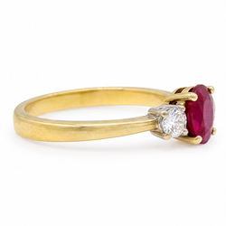 18ct gold ruby and diamond three stone ring, single oval cut ruby of 1.06 carat, with a round brilliant cut diamond set either side, hallmarked, total diamond weight 0.31 carat