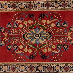 Kashan design wool runner, red field decorated with repeating floral medallions, palmettes and scrolling foliate motifs, enclosed by cream floral border and fringed ends
