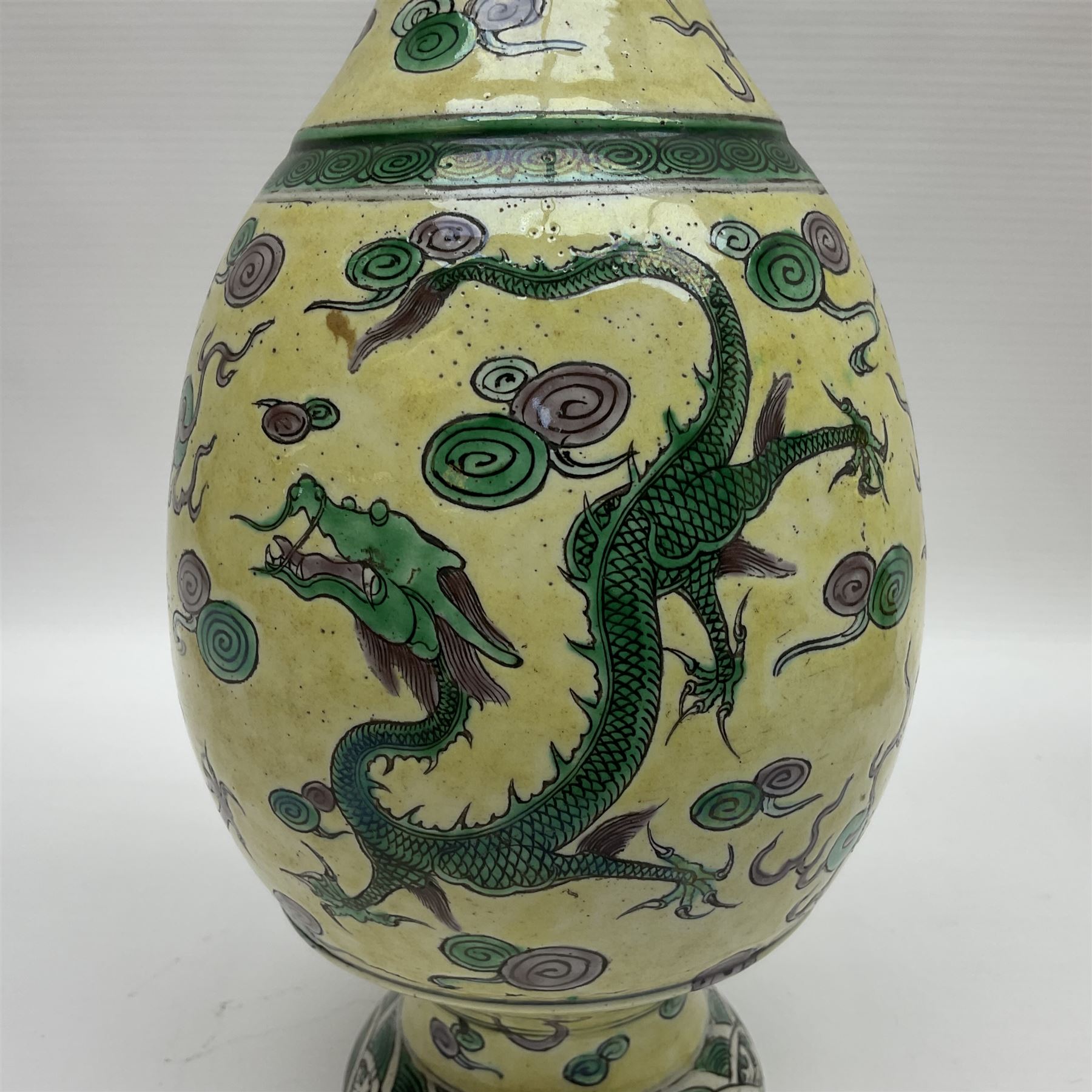 20th century Chinese Famille Verte vase, of slender ovoid form with tapering neck and flared rim, decorated with green and grey enamel with dragons chasing flaming pearls amongst auspicious clouds upon a yellow ground, H30cm