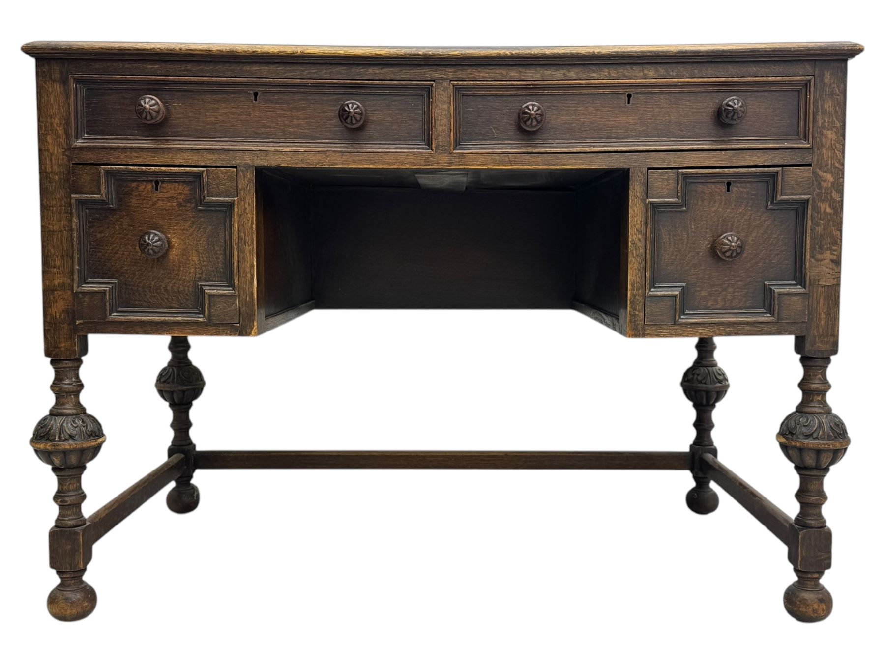Early 20th century Jacobean design oak desk, with rectangular top inset with worn tooled leather, two frieze drawers over pedestals each fitted with a pair of panelled drawers, turned handles, on carved and fluted tapering legs united by stretchers 