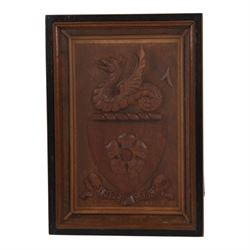 Early 20th century relief carved oak crest depicting shield with central five point flower...