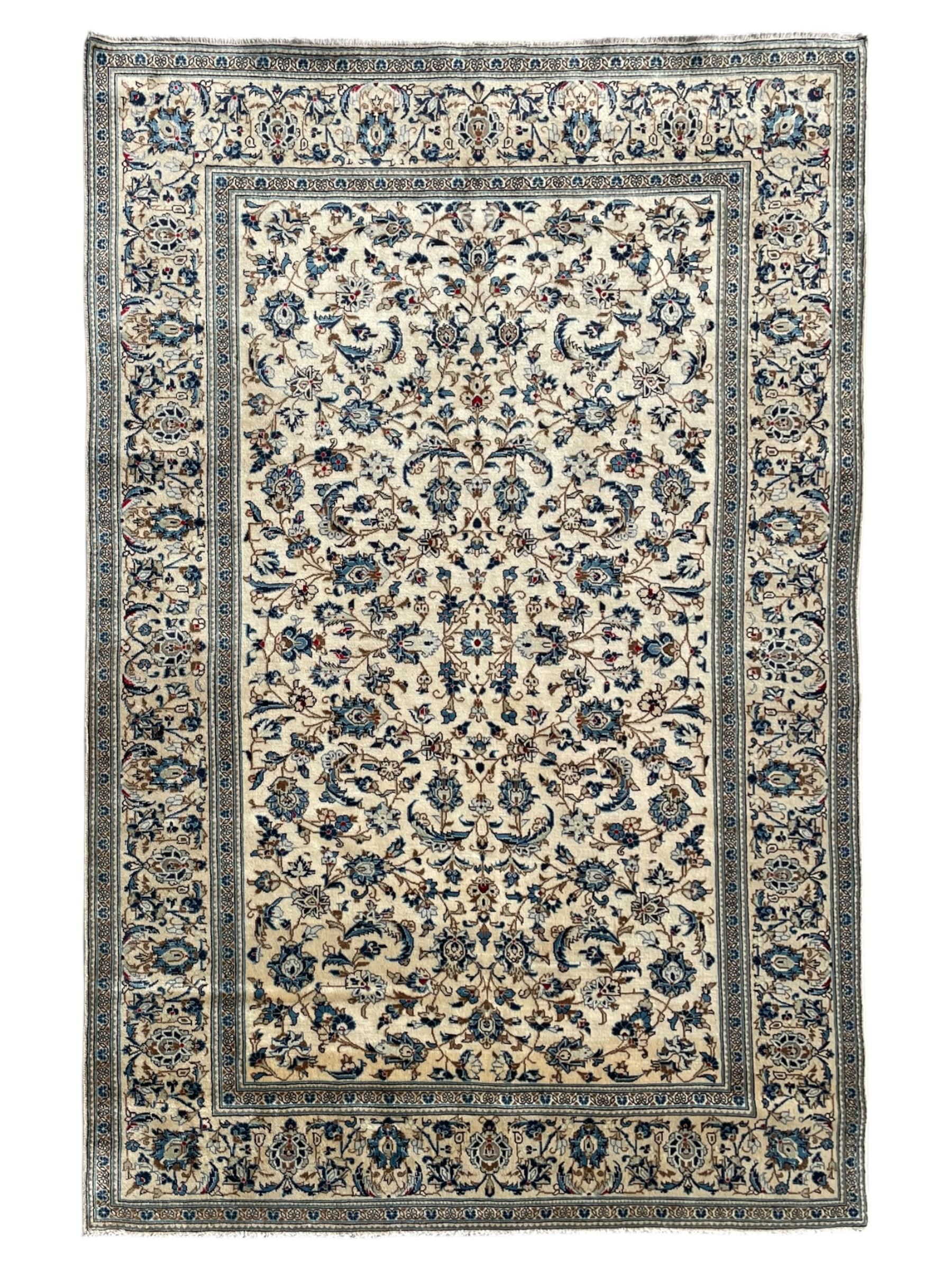 Persian Kashan ivory ground rug, the field decorated with trailing branches with leaves and palmettes, similar scrolling border, within floral pattern guard stripes 