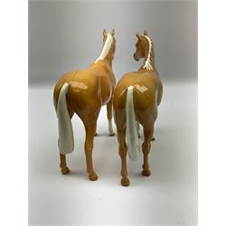 Two Beswick Palomino horse figures, comprising 'Imperial' Palomino, model no. 1557, designed by Albert Hallam and James Hayward, together with Palomino Arab model no. 1771, both stamped, tallest H20cm