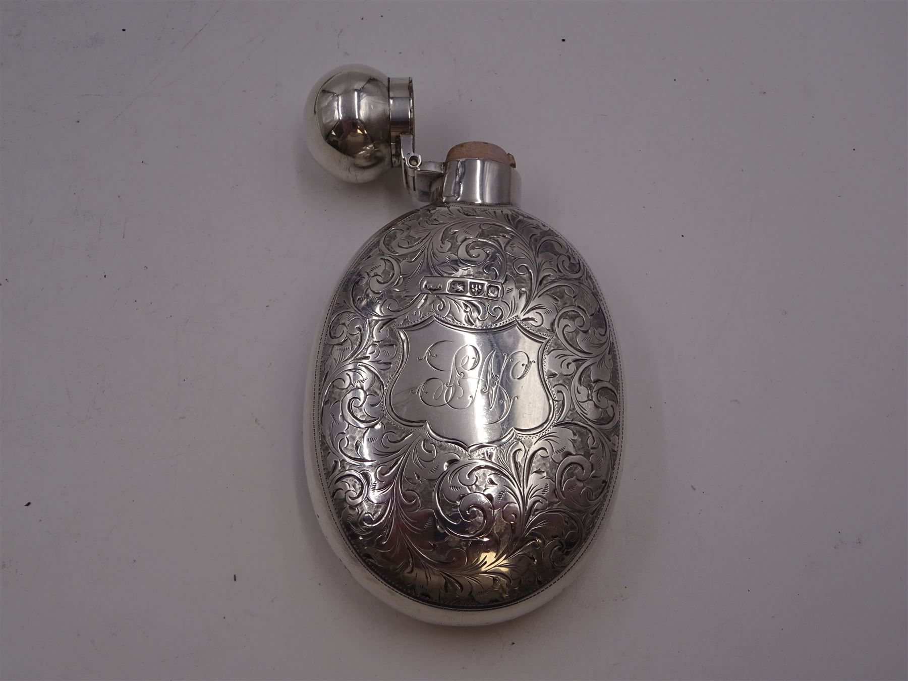 Victorian silver hip flask, of oval form, with engraved foliate and scroll decoration, and monogrammed shield shaped cartouche to centre, with plain collar and cap, H11cm, hallmarked Chester 1899, maker's mark worn and indistinct, together with an Edwardian silver glasses case, of oval form, with engraved foliate and scroll decoration, and monogrammed circular shaped cartouche to centre, with opening to top, revealing velvet lined interior, with silver shield clip, H17.5cm hallmarked to case and clip Sanders & Hill,  Birmingham 1908, with a pair of gold plated glasses 