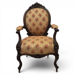 Victorian mahogany open armchair, oval stuff-over back with floral upholstery, moulded and foliate carved frame with pierced crest, padded open arms with scroll terminals, serpentine seat rail on cabriole supports