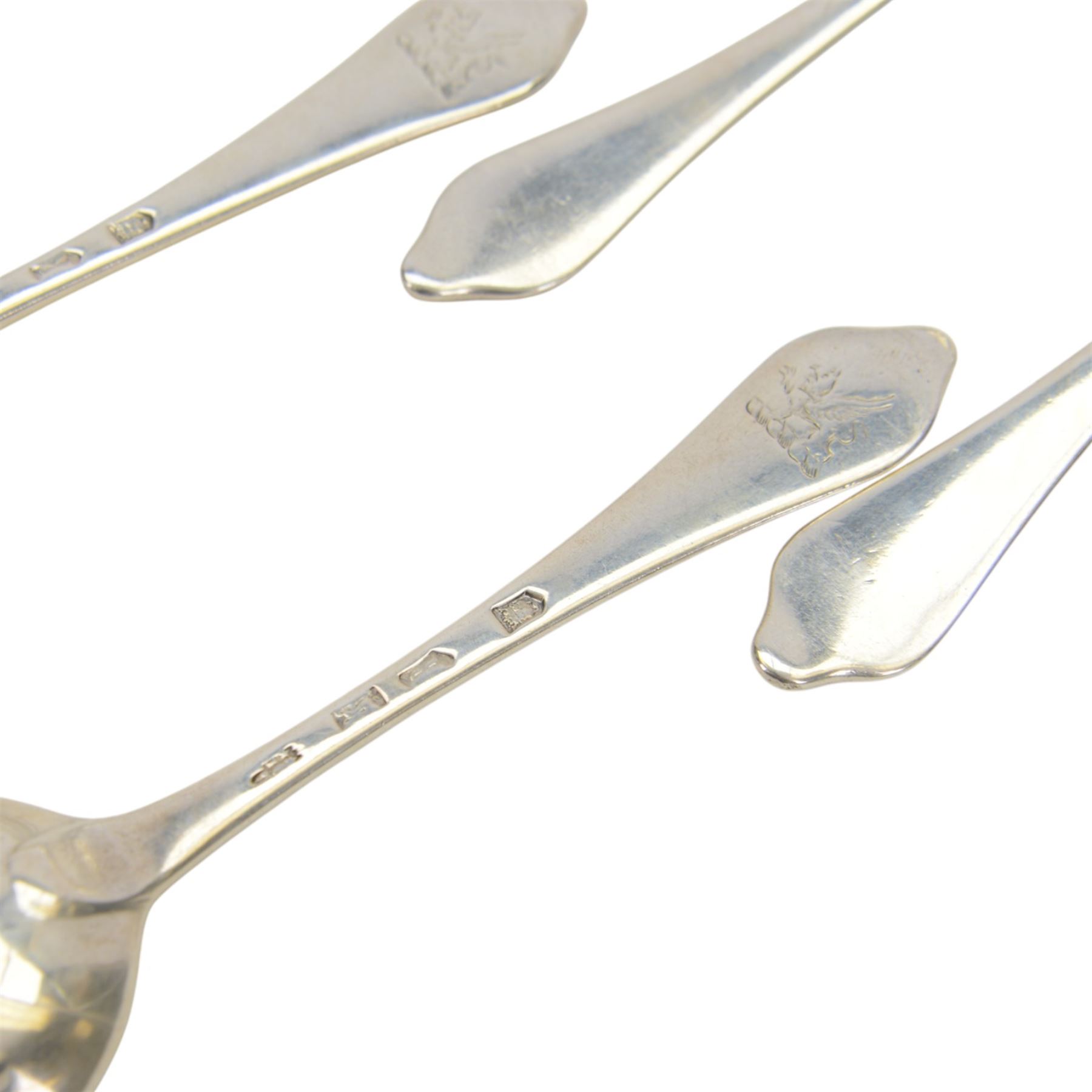 Twelve silver dog nose spoons, comprising a set of eight George II examples with drop heels  and engraved crest to terminals, hallmarked Isaac Callard, London 1732, three with rat tail bowls, circa 1722, hallmarked Samuel Hitchcock, London, date latter worn and indistinct, and a Britannia standard with rat tail bowl, circa 1718, each approximately L20cm