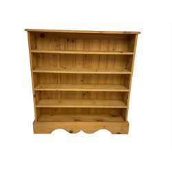 Traditional pine low open bookcase, fitted with four shelves on shaped plinth base