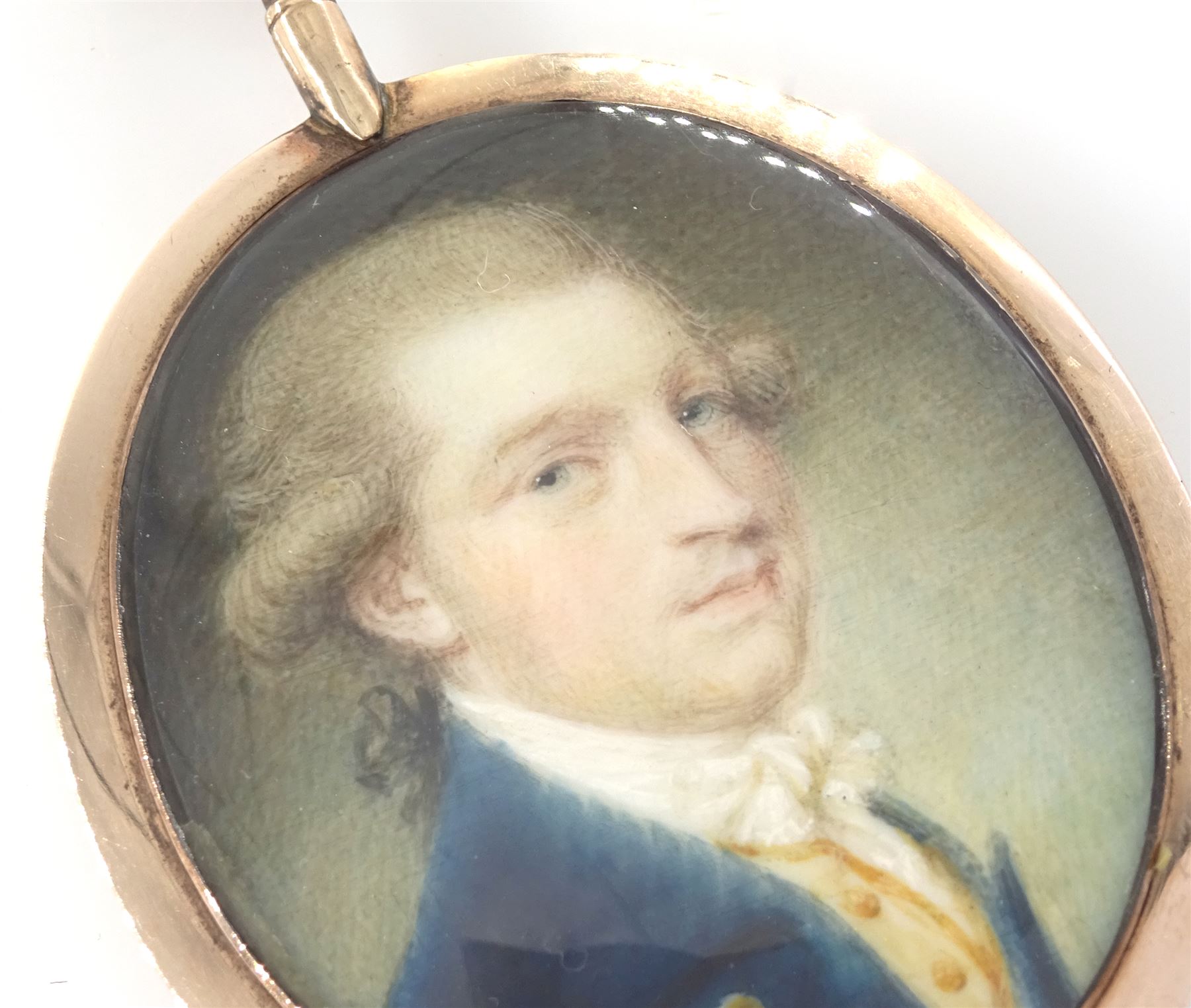 Samuel Shelley (British 1750-1808)
Portrait miniature upon ivory, circa 1790
Head and shoulder portrait of a gentleman in blue coat and yellow waistcoat 
Within period gold fausse-montre case with hair work verso
Oval 3.75cm x 3cm

Samuel Shelley first exhibited at the Society of Artists in 1773, entering the Royal Academy Schools the following year where he exhibited work up until 1804. 
Largely considered to have been self-taught, Samuel Shelley worked in a range of mediums throughout he career, producing watercolours, oils, book illustrations and engravings, but is arguably best known for his miniature portraits in watercolour, a medium which he championed establishing the first watercolour society in around 1804.
Shelley was a prominent and popular miniaturist during his time, and today his works feature in many major museums.  
