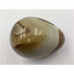 Polychrome jasper specimen egg, in creams, browns and earthy tones, upon a wooden stand, H12cm