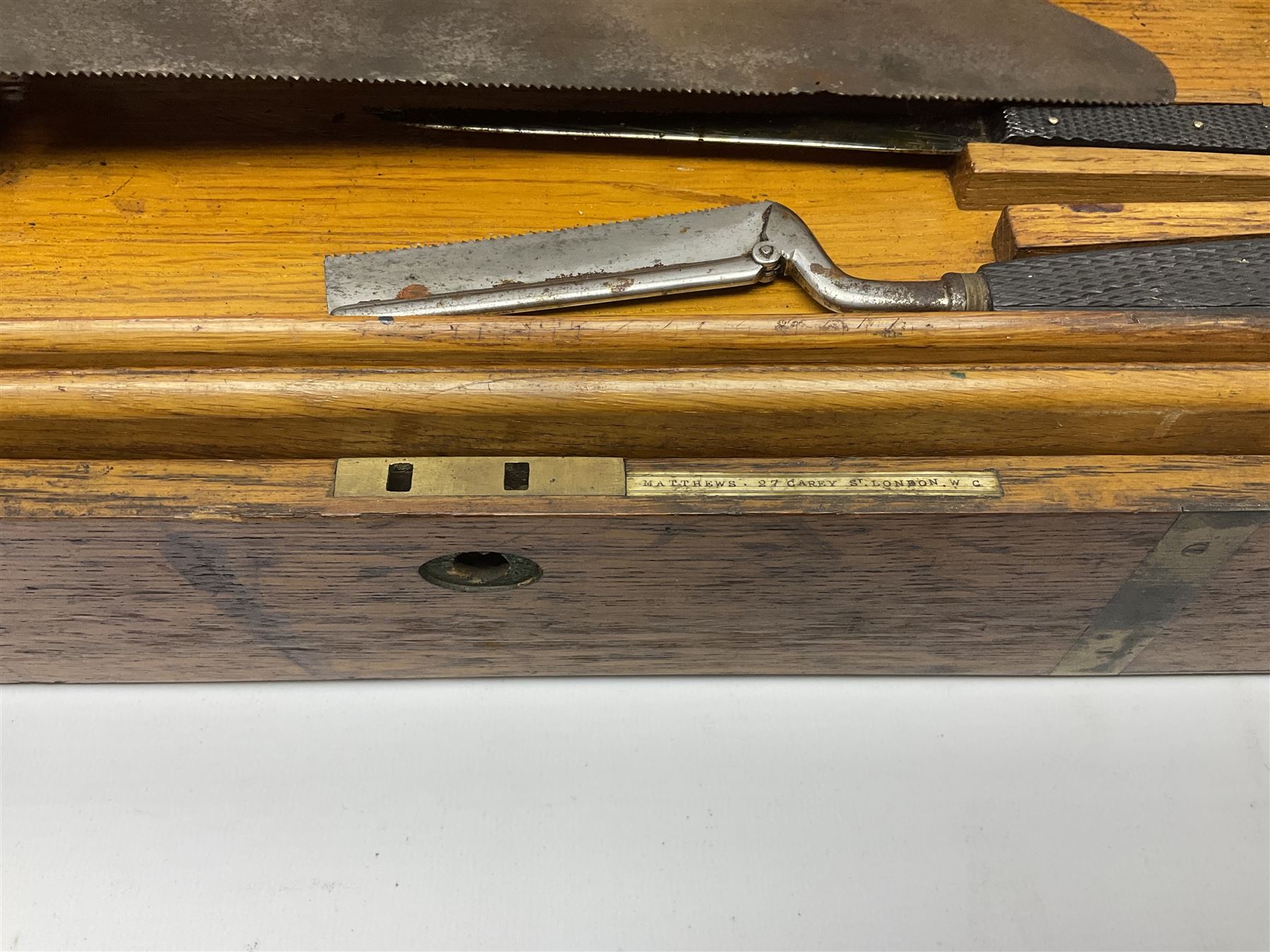 Naval doctor's surgical instruments, contained in a converted brass bound oak pistol box, the hinged lid opening to reveal two removable fitted trays, containing 19th century and later saws, scalpels, tweezers etc