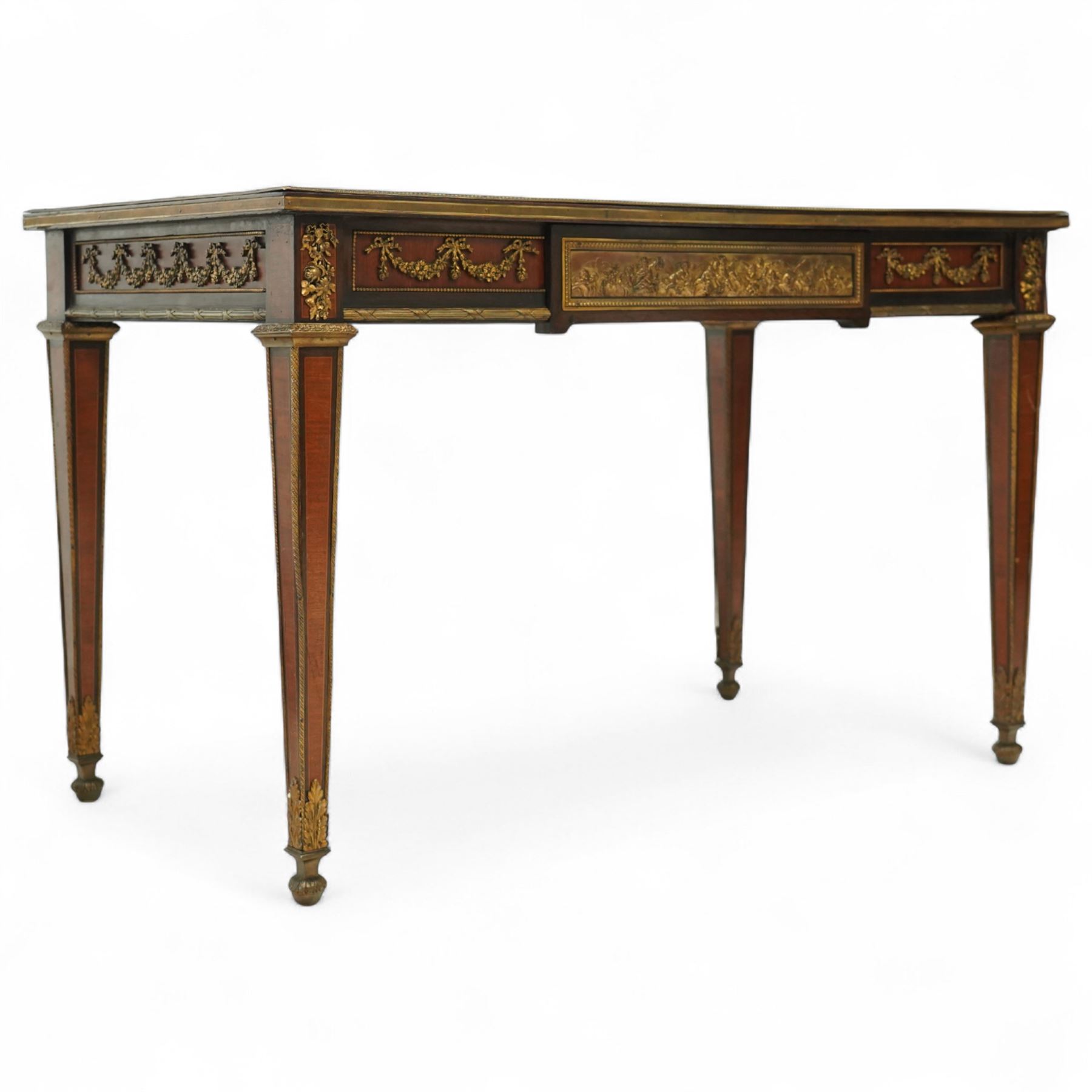 Fine 19th-century Louis XVI-style mahogany and gilt bronze-mounted writing table, rectangular top with a gilt tooled tan leather writing surface within a moulded gilt bronze edge above a frieze fitted with three drawers, mounted with floral and foliate gilt bronze swags  and borders, raised on square tapering legs with acanthus mounts and toupie feet