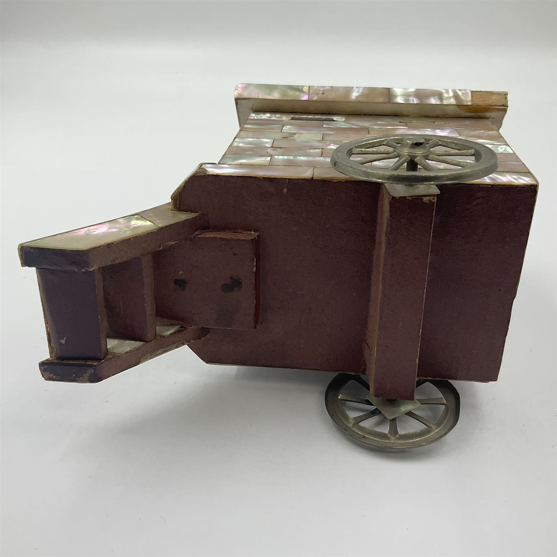 19th century French souvenir jewellery casket in the form of a bathing machine, having mother of pearl panelled tiled effect body, hinged roof/cover revealing a blue silk fitted interior with cushioned base, two silvered metal wheels, abalone shell door and mother of pearl steps, inscribed 'Berck Plage' in blue, H12cm, W13cm 