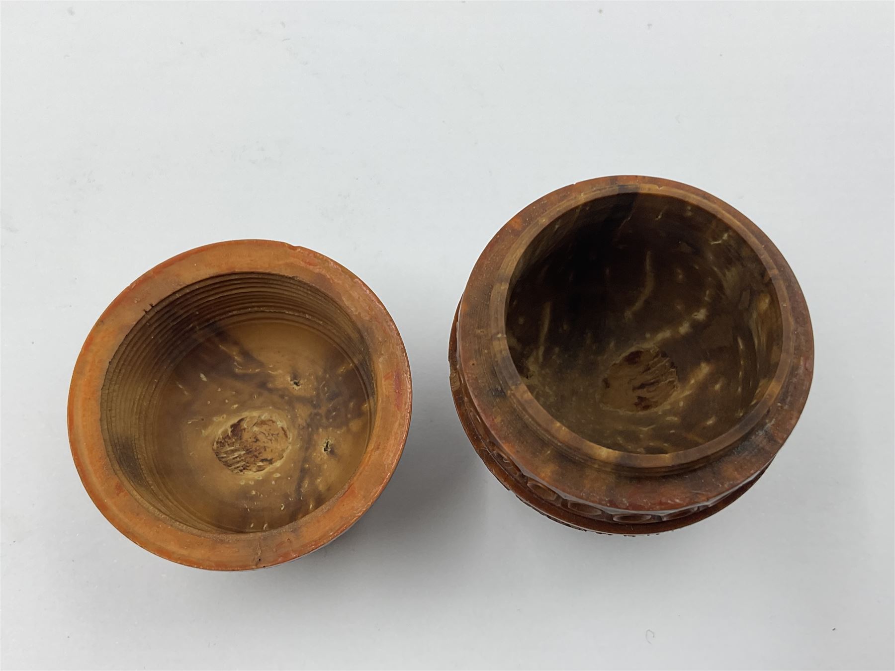 Three 19th century coquilla nut pomanders or flea catchers, two of egg shaped form and the third of barrel from with carved and pierced decoration and screw threaded join, largest H8cm