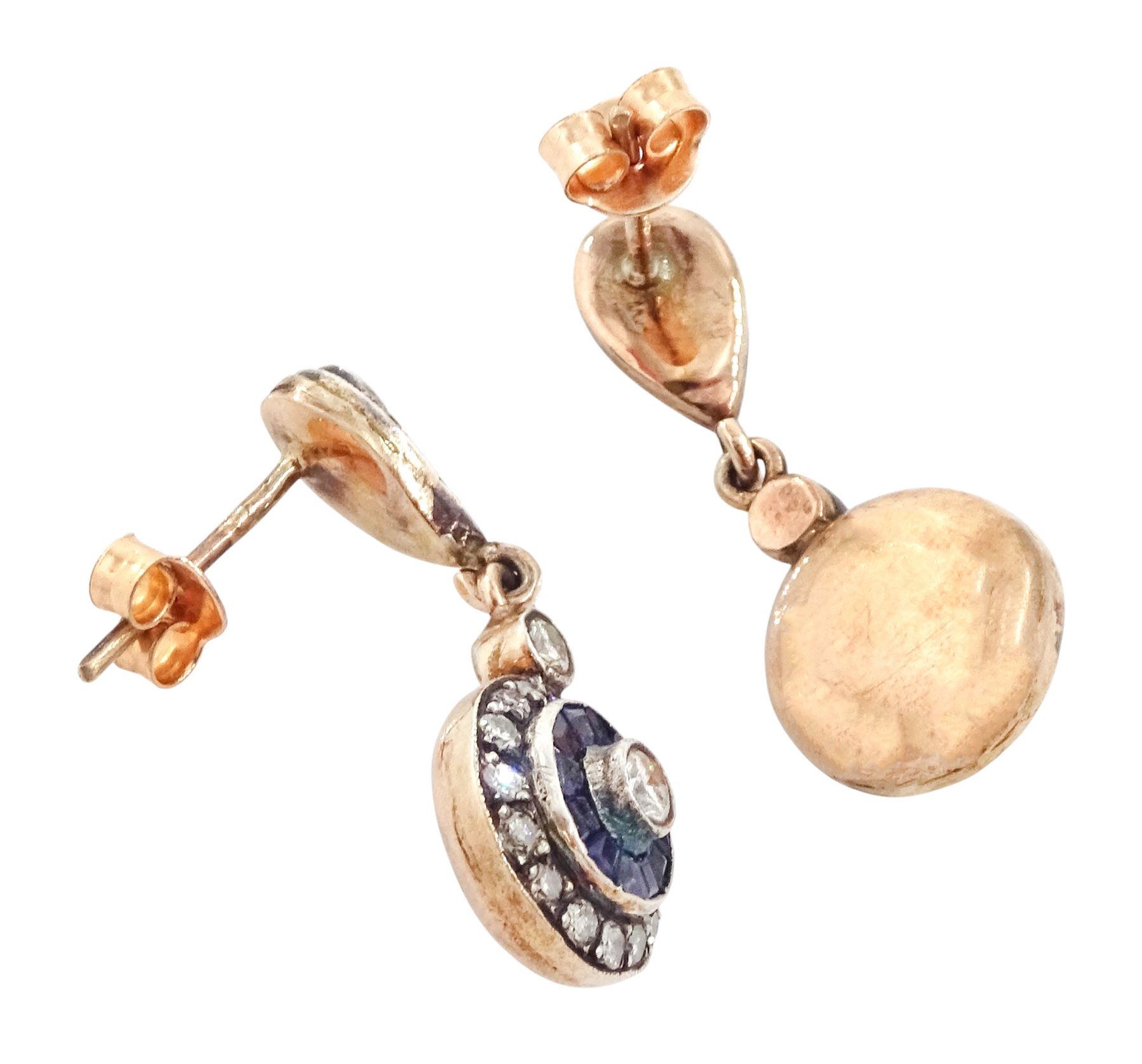 Pair of rose gold and silver diamond and sapphire pendant earrings, each stud set with a round brilliant cut diamond, surrounded by calibre cut sapphires and diamonds, suspending from a single diamond and pierced design diamond tops, total diamond weight approx 0.70 carat, total sapphire weight approx 0.50 carat