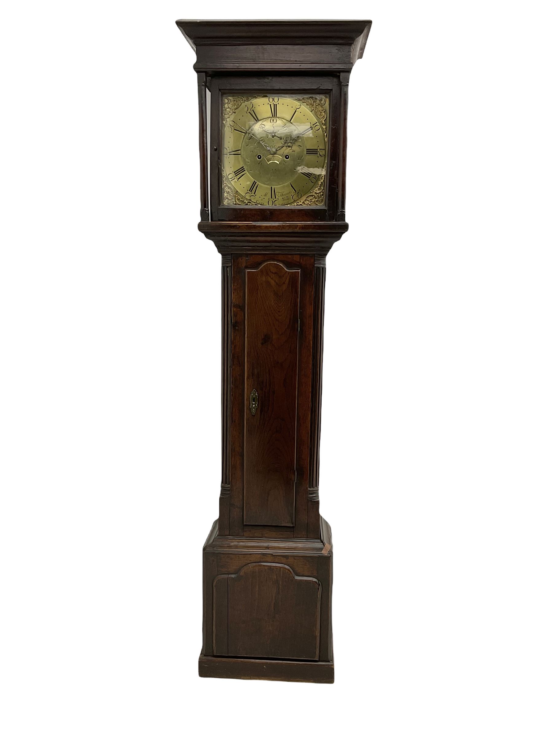 An 18th century oak cased longcase clock by M Thomas & Sons, Carnarvon c1780, flat topped hood with a wide cornice and plain frieze, glazed hood door flanked by two shaped pillars, with a long trunk and  door with a break arch top, with canted and reeded corners on a short plinth with a raised conforming break arch panel and skirting, 13” brass dial with an engraved centre,  small semi-circular date aperture and disc behind, with a subsidiary seconds dial, non-matching steel hands and scroll spandrels, Engraved chapter ring with roman numerals, five minute Arabic's and minute markers, dial pinned directly to an eight day rack striking movement, striking the hours on a cast bell. With weights, pendulum and key.    
Michael and Morris Thomas are recorded as working together in Carnarvon 1769-94.





