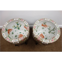  Pair of large Cantonese style Famille Rose fish bowls, decorated with panels of figures on a floral and insect painted ground, the interior painted with Carp swimming amidst water weeds on hardwood stands (H41cm x D48cm excluding stands)  