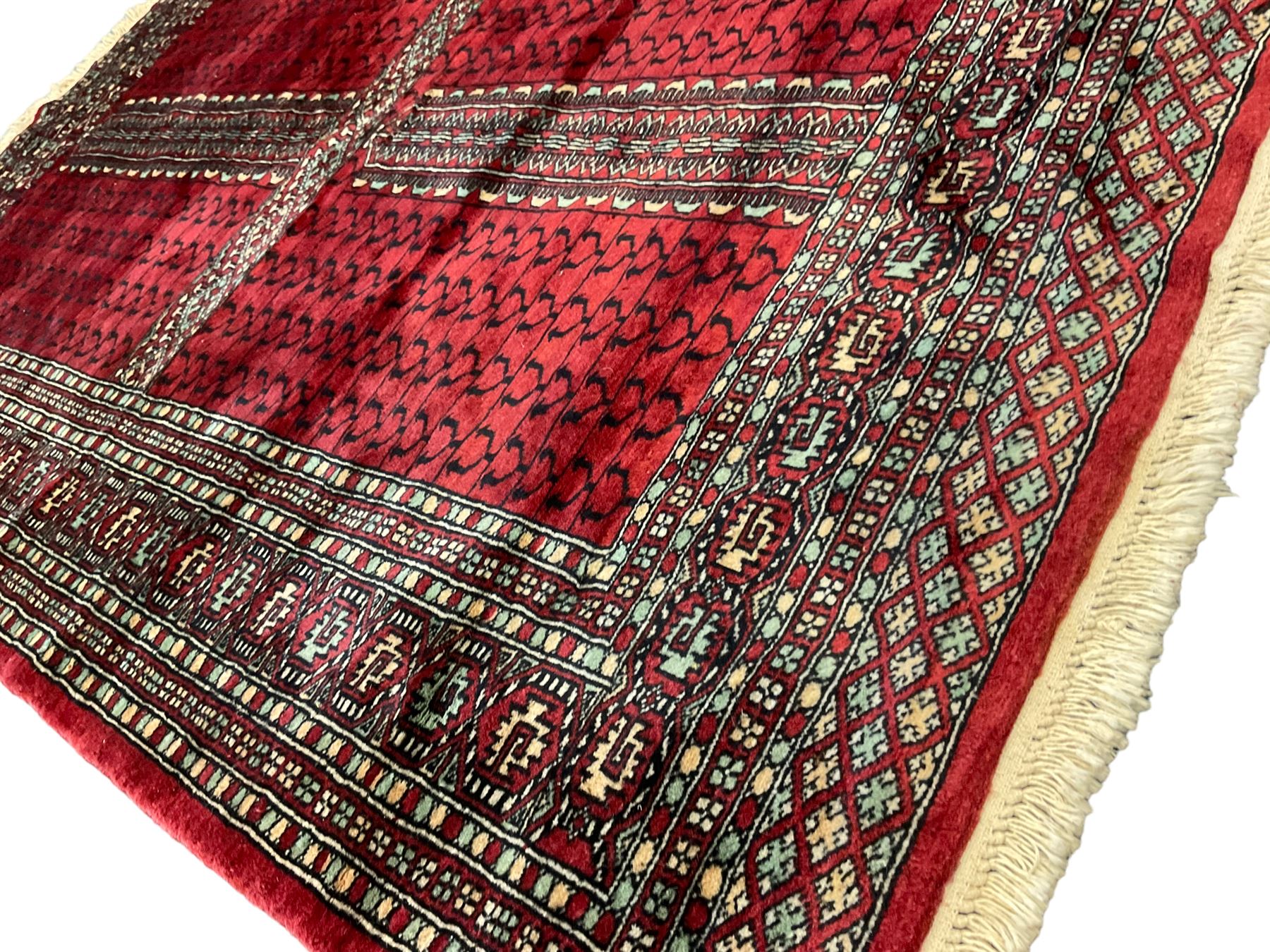 Tekke Ensi crimson ground rug, the quartered field decorated with candelabra motifs, multi-guarded border with repeating geometric hexagonal lozenges in blue and ivory