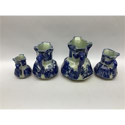 Set of four blue and white ironstone graduated jugs decorated with town scenes, figures and trees, all stamped beneath, tallest H23cm