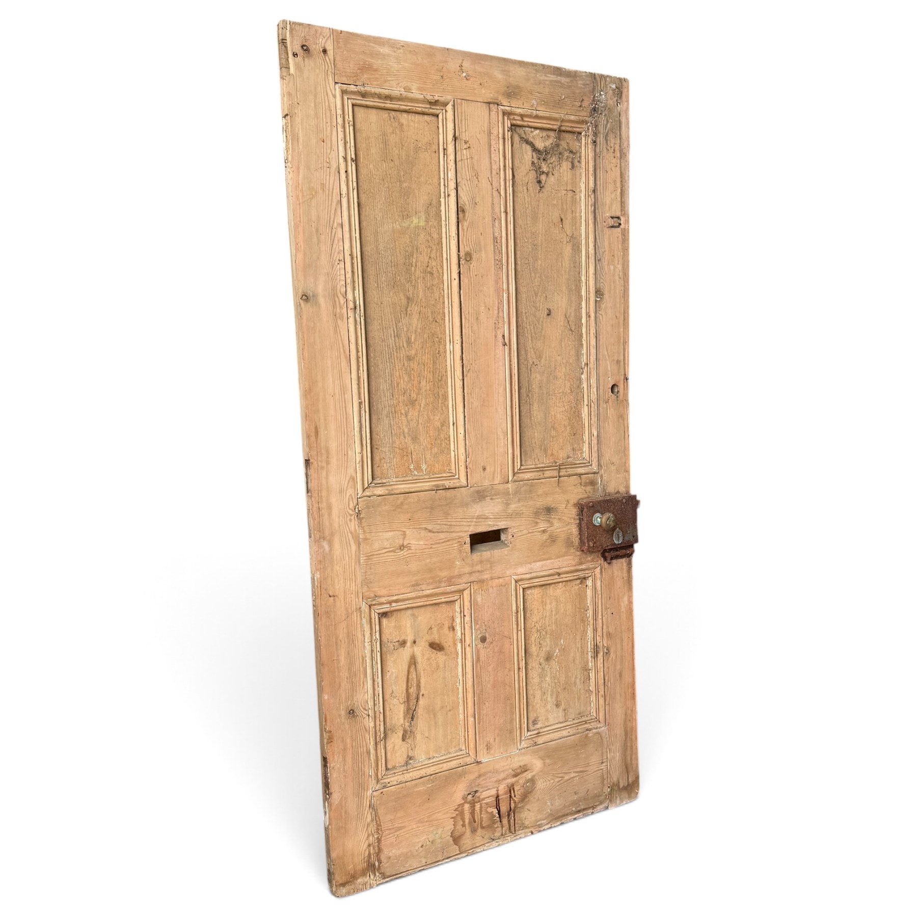 Victorian stripped pine four-panel door, the raised fielded panels within carved foliate and moulded surrounds, with iron lock and fittings and brass knob handle