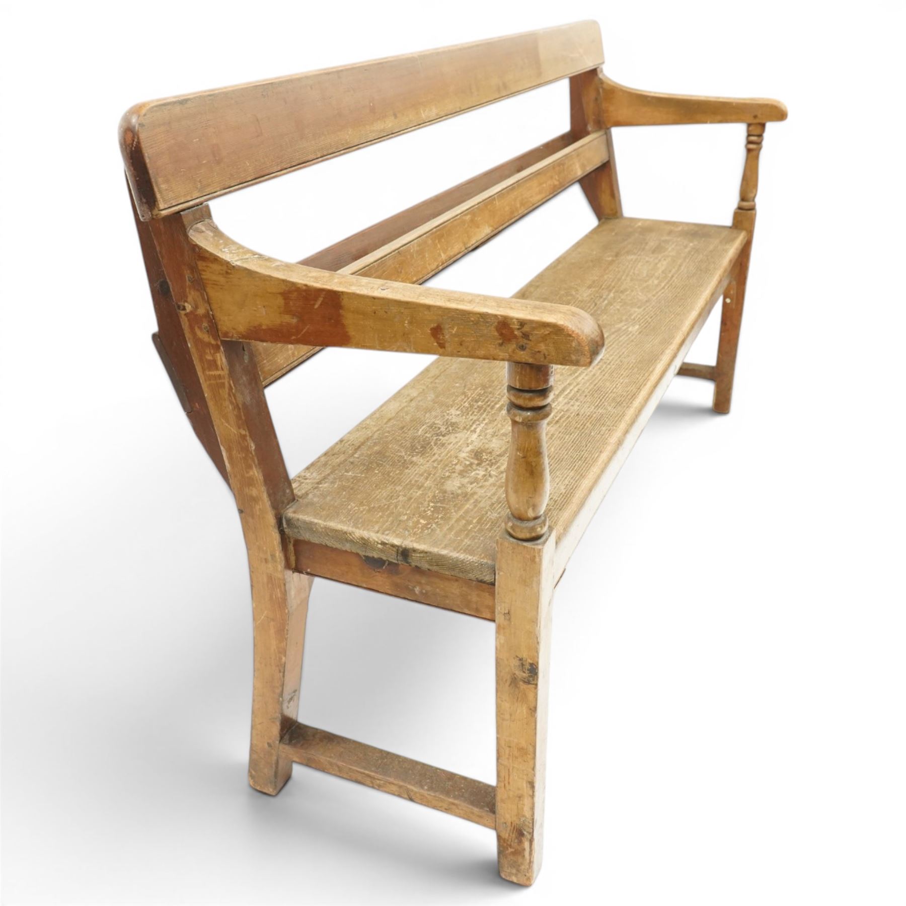 Early 20th century pine chapel bench, with moulded plank back rail over plain rail, with book storage to the back, open shaped end supports with curved arms, turned front uprights, plank seats, square legs united by low stretchers