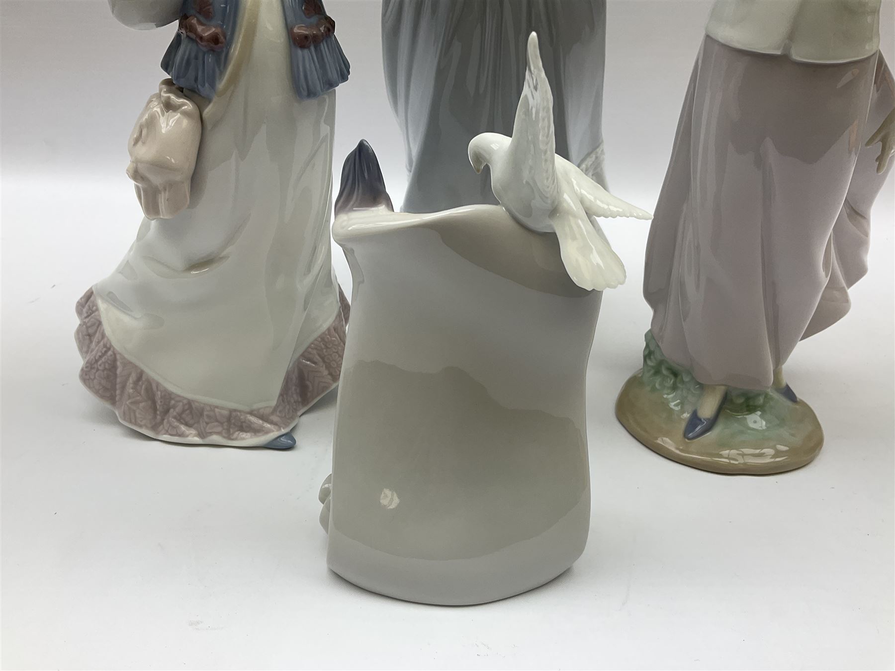 Three Lladro figures, comprising, Dreams of Summer Past no 6401, Spring Breeze no 4936 and Breezy Afternoon 5682 together with Lladro plaque Art Brings us Together no 7677, all in original boxes, largest example H35cm