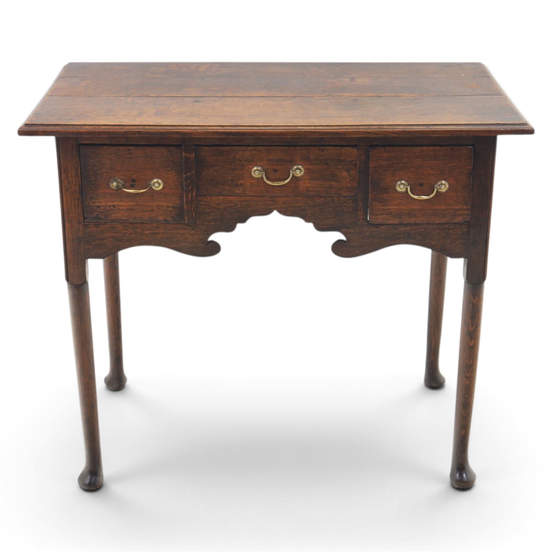 18th century oak lowboy, rectangular plank top with moulded edge, above three assorted drawers with brass swan neck handles, shaped apron raised on pad feet