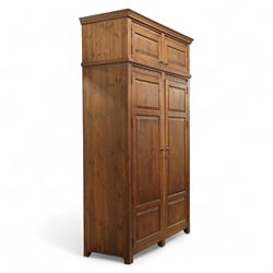 Traditional design contemporary dark stained pine double wardrobe with top box, twin three panelled door with wooden studded frieze, enclosing a single metal rail, with a top box above with brass handles