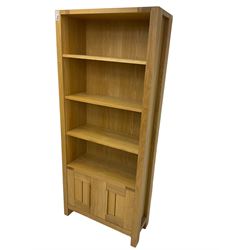 Light oak open bookcase, three adjustable shelves over double cupboard