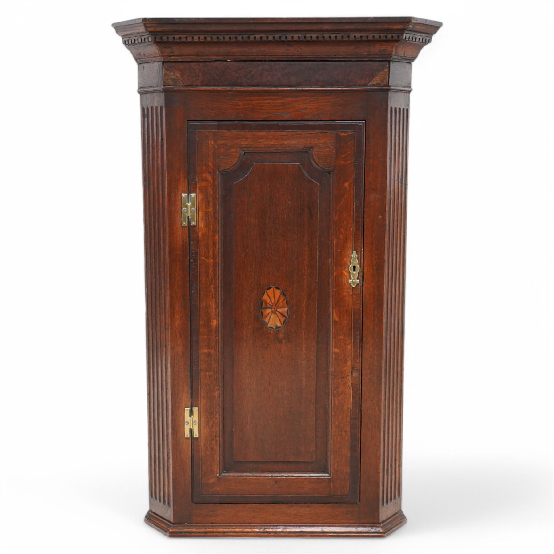 19th century mahogany corner wall cupboard, with projecting cornice and dentil moulding above a single door with shaped fielded panel and satinwood fan inlay, flanked by fluted pilasters, fitted with shaped interior shelving