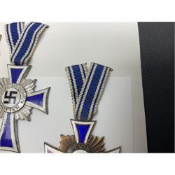 WWII set of three German Mother's Crosses, 1st Class in gilt, 2nd Class in silver and 3rd Class in bronze; all with ribbons (3)