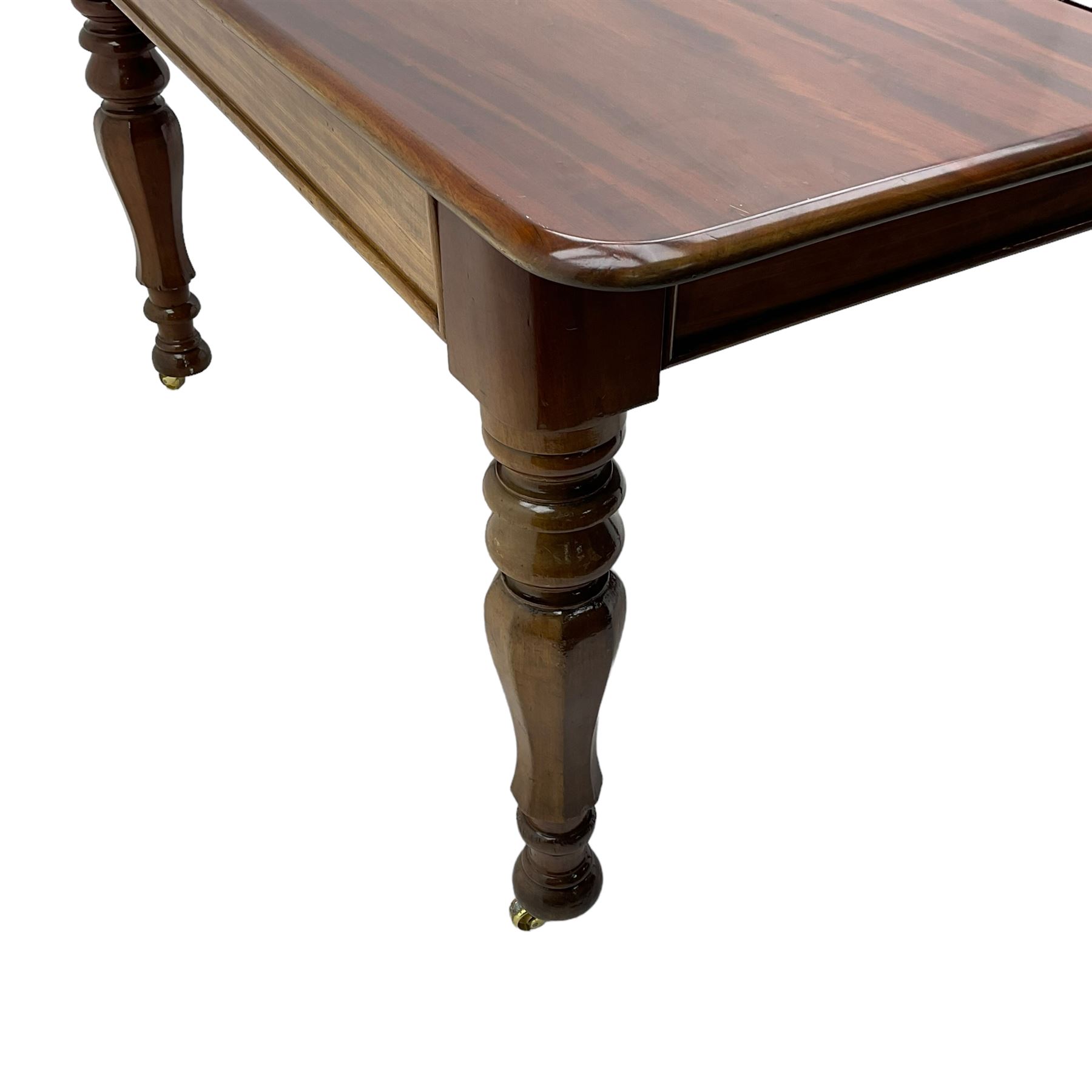 19th century mahogany extending dining table with three additional leaves, rectangular top with rounded corners, pull-out action, on turned and faceted supports with brass castors
