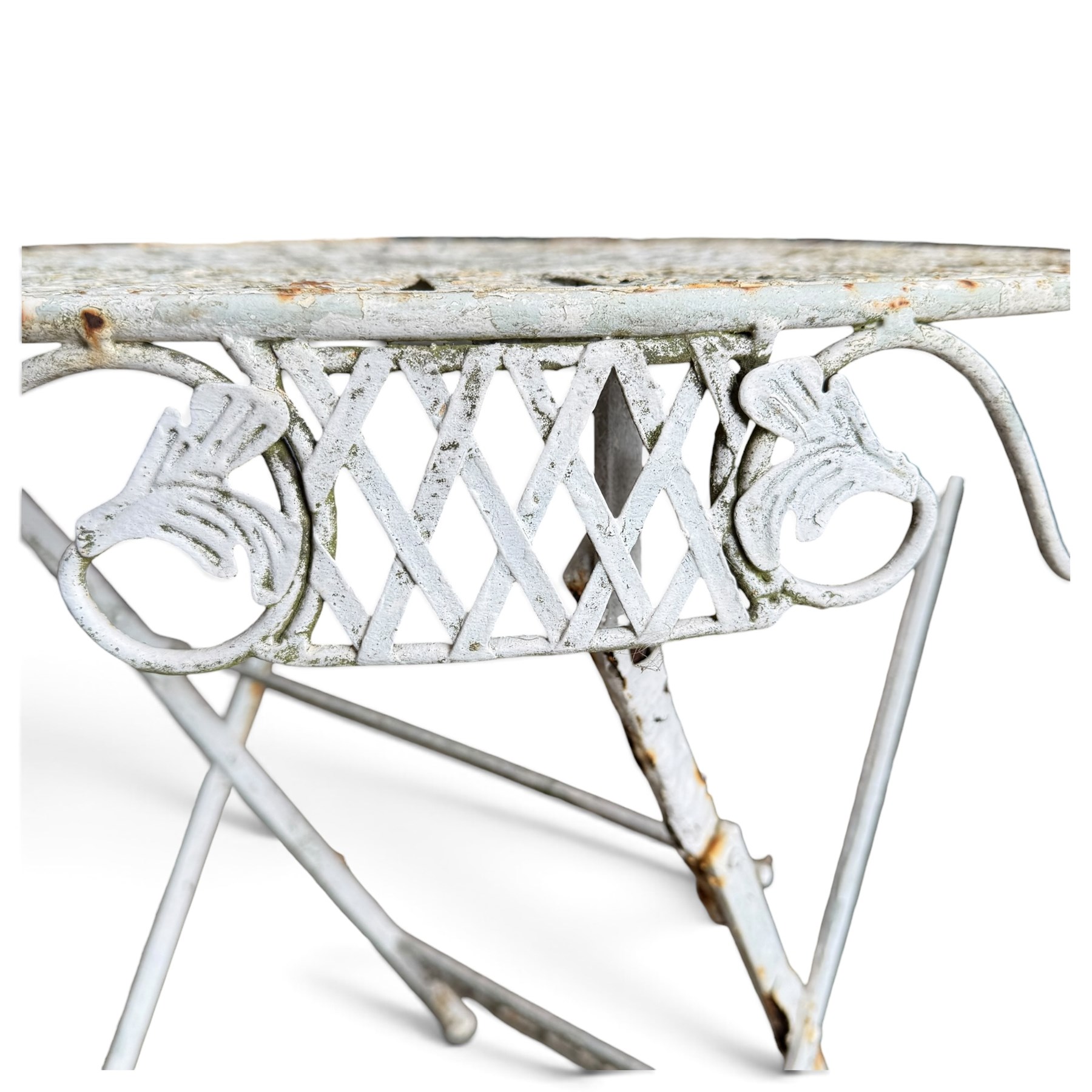 Three-piece French style white-painted wrought iron garden bistro set, comprising a circular folding table with latticework top and apron with scrolling foliate motifs (W70cm H80cm) and matching pair of chairs, with scrolling cresting rail and acorn finials over a scrolled foliate medallion, raised on lattice seat and folding X-frame base (W42cm H93cm)
