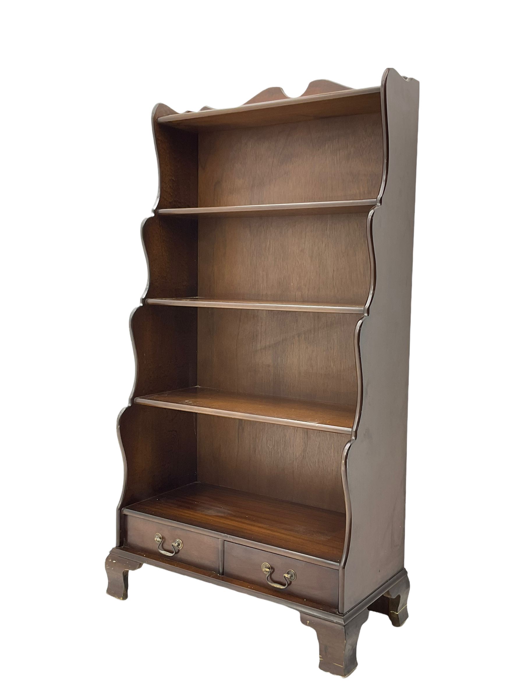 Late 20th century mahogany waterfall bookcase, fitted with two drawers, on bracket feet