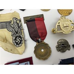 Collection of approximately sixty worldwide medals, metal badges, belt buckles, cloth badges, trench art, brass button stick etc