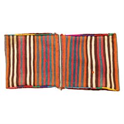 South West Persian Qashgai saddlebag, (Khorjin), woven in geometric designs with central lozenge medallions on a rich madder red ground, decorated with tribal motifs in indigo, ivory green, and ochre, the reverse  with panels of stripped flatwoven kilim 