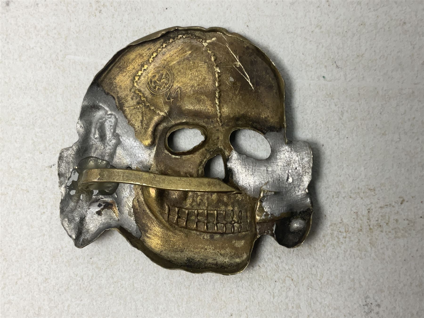 Two WW2 German 'SS' visor cap skull badges and another later; and visor cap eagle insignia (4)